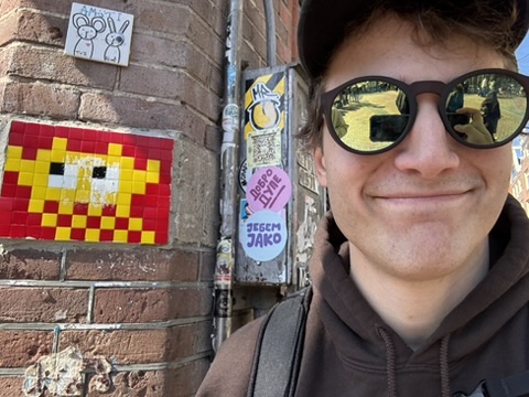 Sawyer next to a pixel invader mural